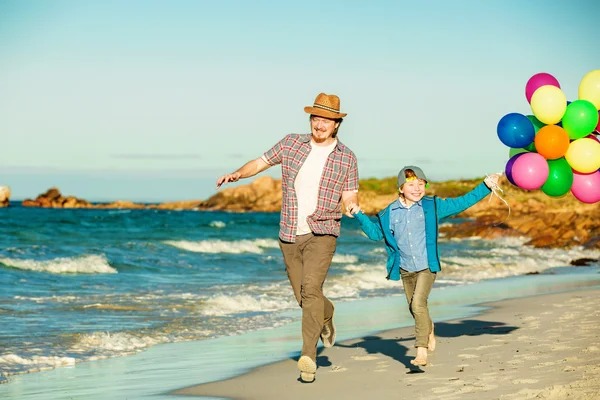 Heureux père et fils passer du bon temps sur la plage au coucher du soleil — Photo