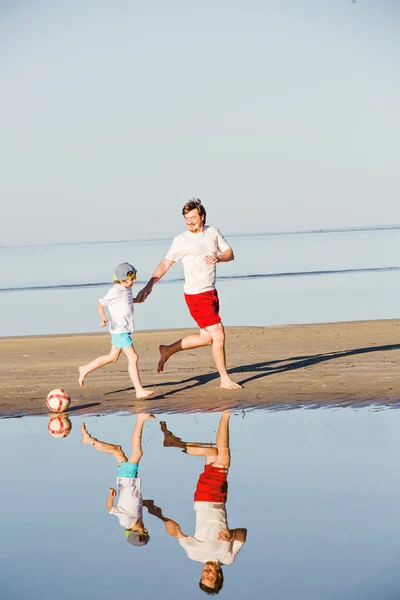 Feliz padre e hijo juegan fútbol o fútbol en la playa —  Fotos de Stock