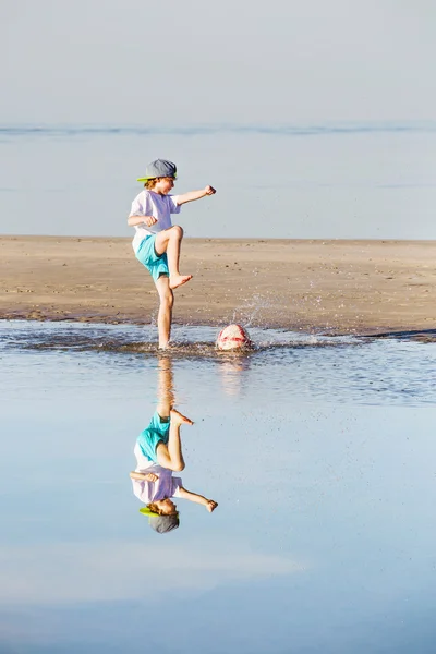 Happy boy play soccer or football on the beach — Stock Photo, Image