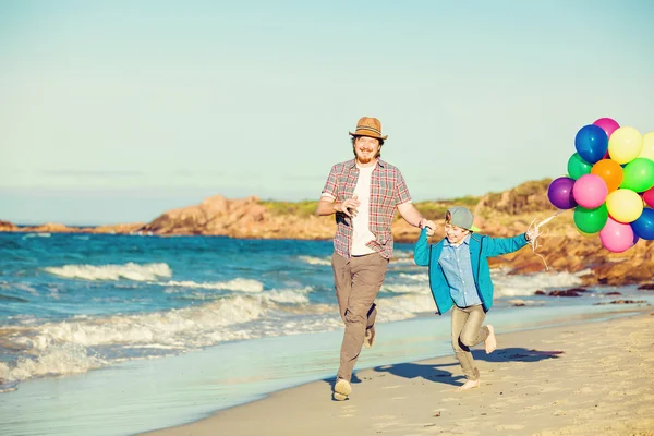 Heureux père et fils passer du bon temps sur la plage au coucher du soleil — Photo