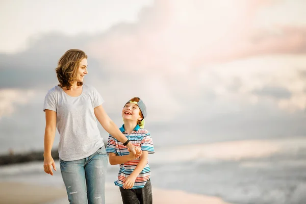 Junge glückliche schöne Mutter und ihr Sohn haben Spaß am Strand. positive menschliche Emotionen, Gefühle Konzept — Stockfoto