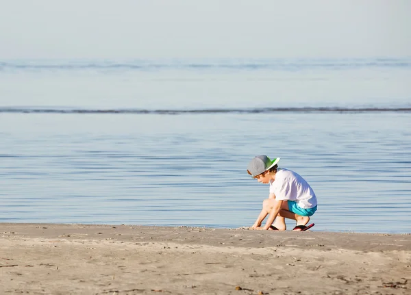 Happy boy play with sand on the beach — Stock Photo, Image