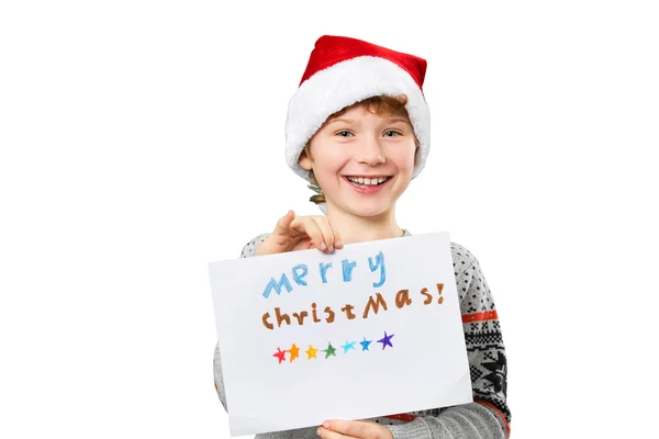 Portrait of a boy in christmas hat holding blank. Isolated — Stock Photo, Image
