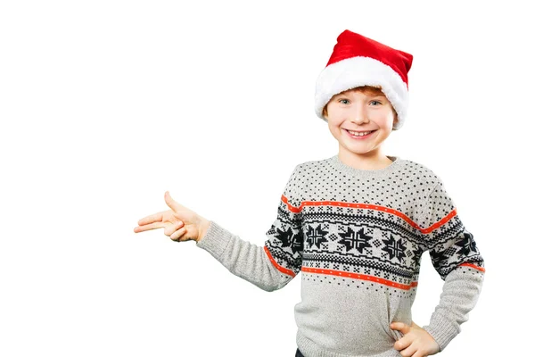 Portréja egy fiú karácsonyi kalapban mutat valamit az ujjaival. Elszigetelt — Stock Fotó