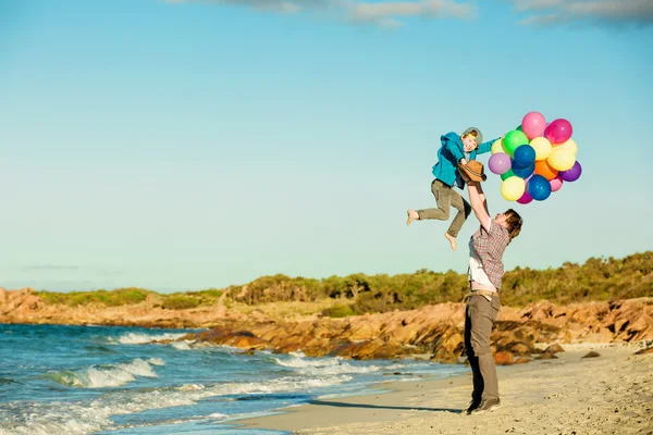 Feliz padre e hijo pasando un buen rato en la playa en la luz del atardecer — Foto de Stock