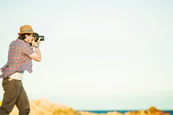 Joven fotógrafo tomando fotos en la playa — Foto de Stock