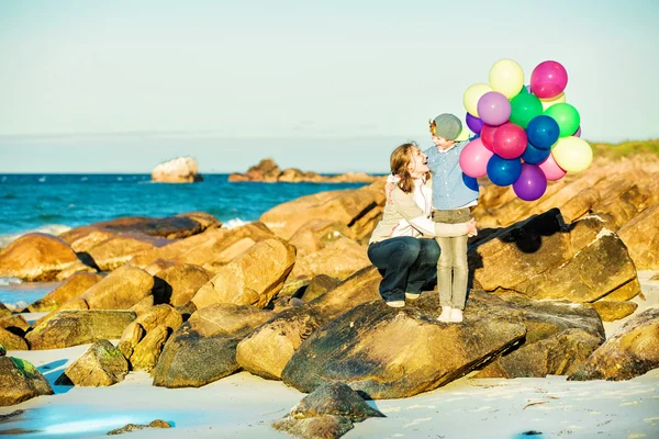 Glückliche Mutter und Sohn haben viel Spaß am Strand im Sonnenuntergang — Stockfoto