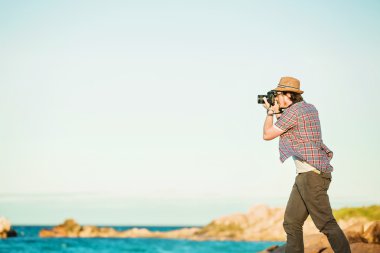 Genç fotoğrafçı plaj fotoğraflar çekmek 