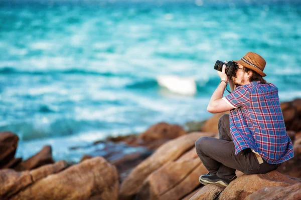 Jovem fotógrafo tirando fotos na praia — Fotografia de Stock