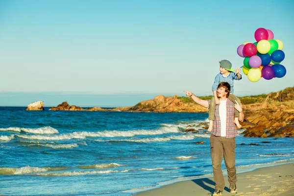 Heureux père et fils passer du bon temps sur la plage au coucher du soleil — Photo