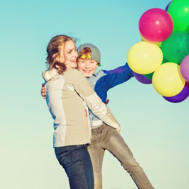 Mutlu anne ve oğlu sahilde günbatımı ışığı iyi vakit geçiriyor