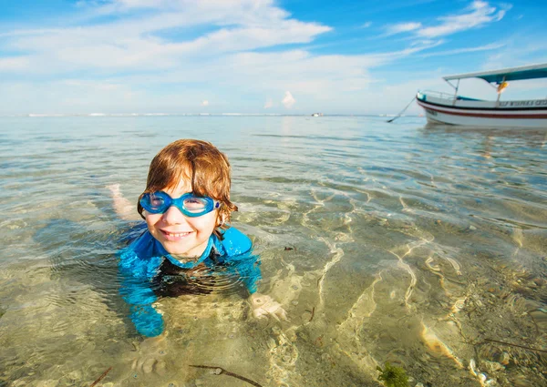 Happy smiling boy with goggles on swim in shallow water — Zdjęcie stockowe