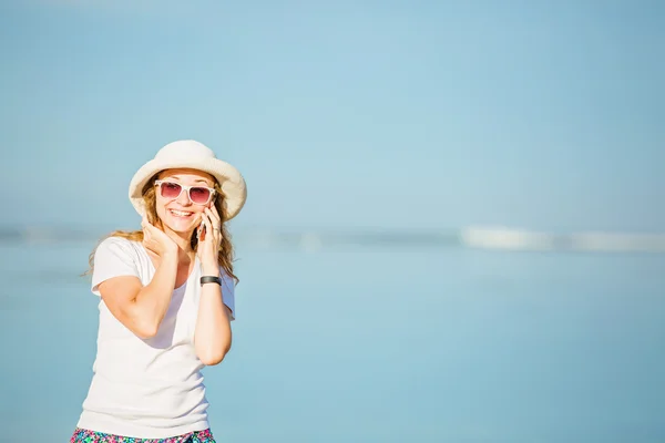 Hermosa joven en la playa hablando por teléfono móvil y riendo —  Fotos de Stock