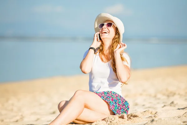 Hermosa joven en la playa hablando por teléfono móvil y riendo —  Fotos de Stock