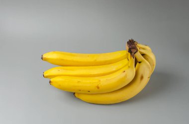 Gri arka planda bir avuç muz. 2021 Aydınlatma ve Nihai Gri 'nin moda rengi. Yan görünüm asgari yaşam.