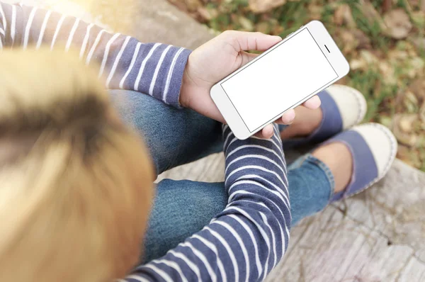 Vrouw zitten en houden scherm telefoon wit in park — Stockfoto