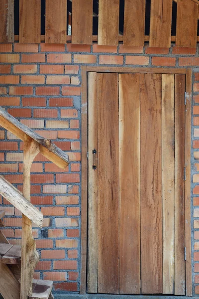 Wood door on brick wall of house — Stock Photo, Image