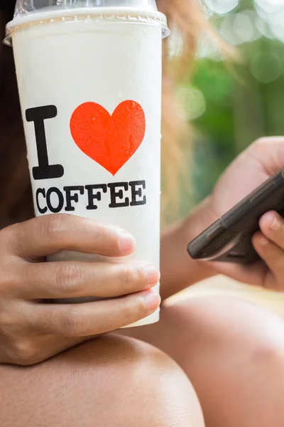 Ženy drží ledové kávy a využít chytrý telefon mobilní — Stock fotografie