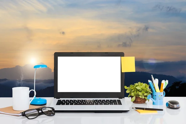 Bärbar dator på skrivbordet och landskap bakgrunden — Stockfoto
