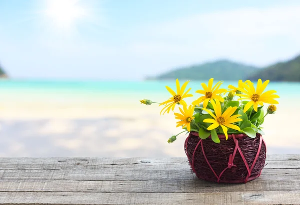 木製のテーブルとビーチの背景に花の花瓶 — ストック写真