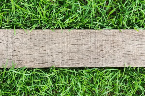 Grain wood on green grass — Stock Photo, Image