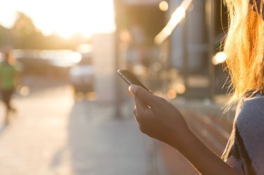 gün batımında Smartphone kullanarak closeup kadınlar