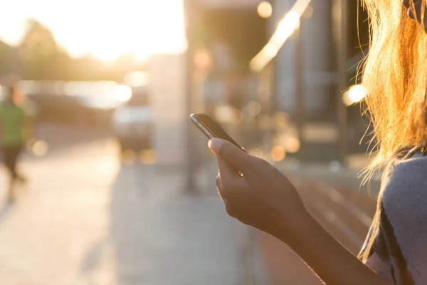 Mujeres de primer plano usando smartphone al atardecer —  Fotos de Stock