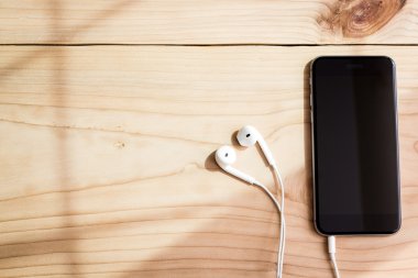 telefon ve kulaklık ahşap arka plan üzerinde