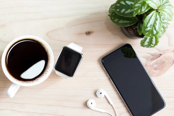 Phone and hand watch on wood desk top view — Stock Photo, Image