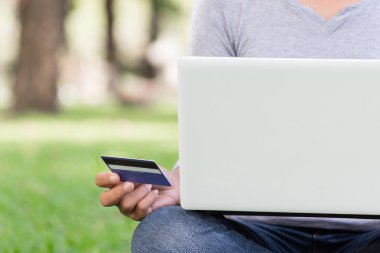 laptop ve kredi kartı alışveriş online parkta kullanan kadın