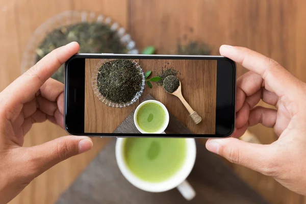 Zbliżenie ręki trzymającej telefon strzelanie napój photogeaph — Zdjęcie stockowe