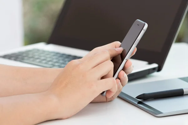 Hand touch svart telefon på skrivbord — Stockfoto