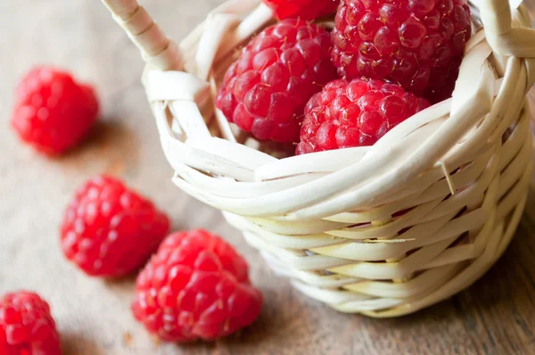 Nahaufnahme von Himbeeren in einem Holzkorb auf Holztischhintergrund — Stockfoto