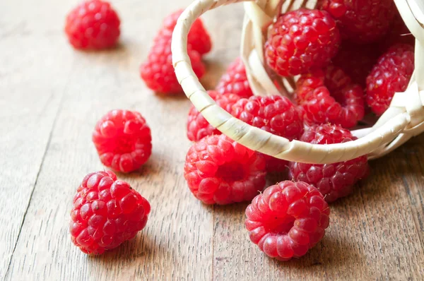 Nahaufnahme von Himbeeren in einem Holzkorb auf Holztischhintergrund — Stockfoto