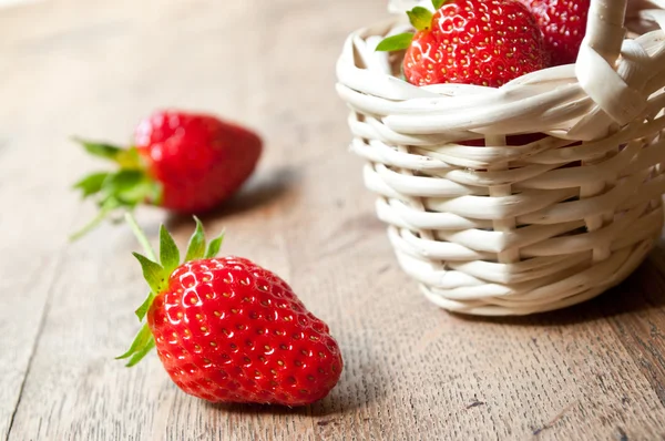 Nahaufnahme von Erdbeeren in einem Holzkorb auf hölzernem Tischhintergrund — Stockfoto