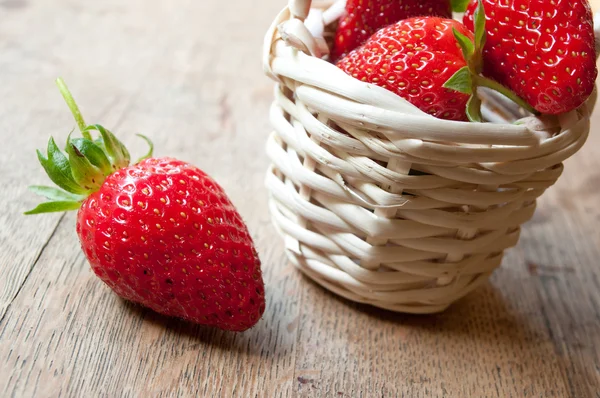 Nahaufnahme von Erdbeeren in einem Holzkorb auf hölzernem Tischhintergrund — Stockfoto