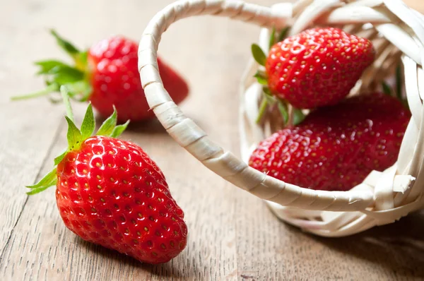 Nahaufnahme von Erdbeeren in einem Holzkorb auf hölzernem Tischhintergrund — Stockfoto
