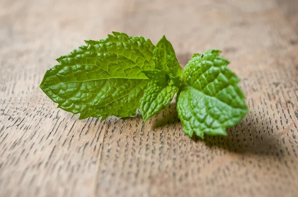 Closeup of leaves of mint on wooden table background Stock Photo