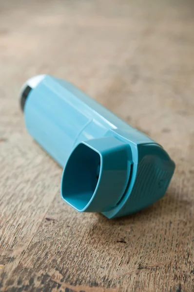 Close-up van astma aërosol op houten tafel achtergrond — Stockfoto