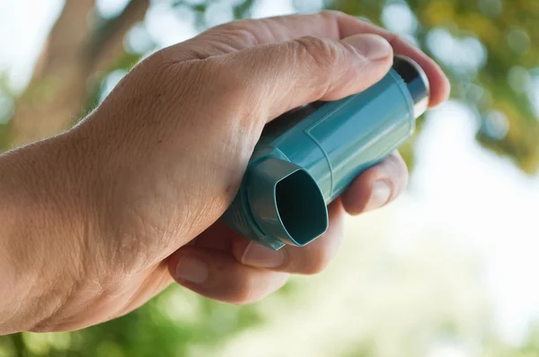 Gros plan de la main avec l'aérosol d'asthme en plein air — Photo