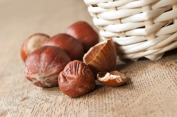 Primer plano de tuercas en cesta sobre fondo de madera — Foto de Stock