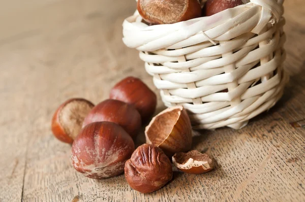 Primer plano de tuercas en cesta sobre fondo de madera — Foto de Stock