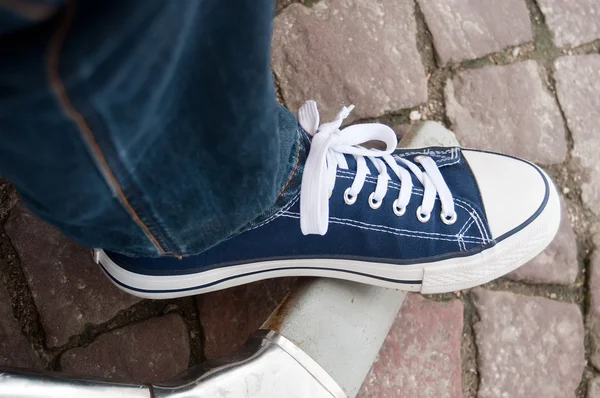 Ноги в синих летних кроссовках и синих джинсах — стоковое фото
