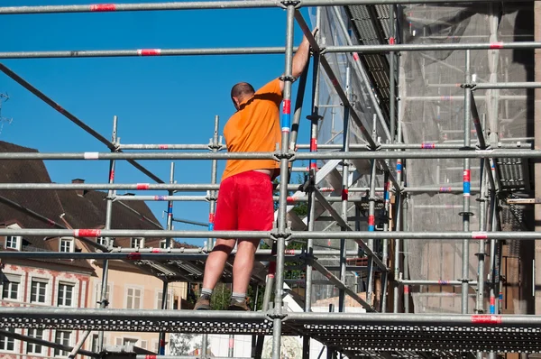 Pracovník na scafold na renovaci webu — Stock fotografie