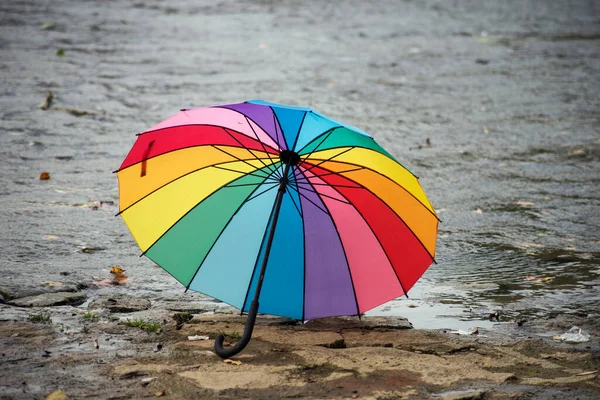 View of rainbow umbrella on the rocks in border river