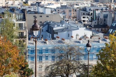 Montmartre 'nin arka planından Paris' in çatılarındaki sokak lambalarının kapatılması. 