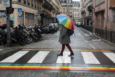 Paris - Fransa - 25 Ekim 2020 - Yaya yolunda gökkuşağı şemsiyesiyle yürüyen kadın portresi