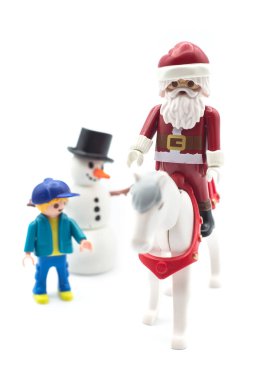 Mulhouse - Fransa - 17 Aralık 2020 - Beyaz arka planda bir at ve kardan adam üzerindeki Playmobil Noel Baba heykelciğinin yakın çekimi