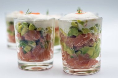 Beyaz arka planda küçük bardaklarda aperatiflerin yakın çekimi