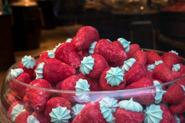 Şekerci dükkanının vitrininde çilek şeklinde şekerlemeler yığılıyor.